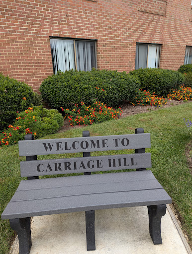 A welcoming bench at Carriage Hill, surrounded by lush landscaping.