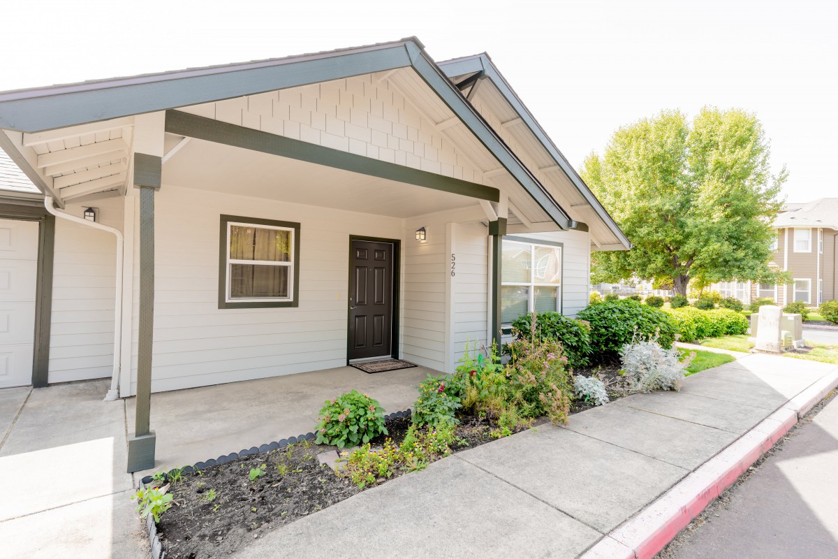 A charming house entrance with a small garden and porch area.