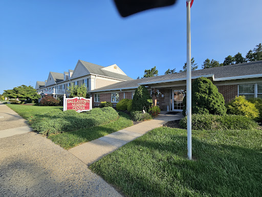 A well-kept building with a flag in front and clear signage, surrounded by lush greenery.