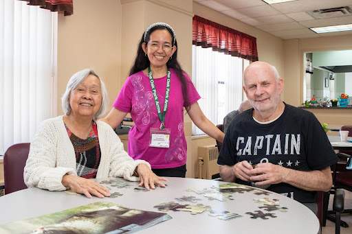 A cheerful gathering of individuals engaged in puzzle solving, showcasing community interaction and shared moments.