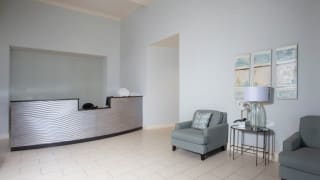 A minimalist reception area with a desk and seating.