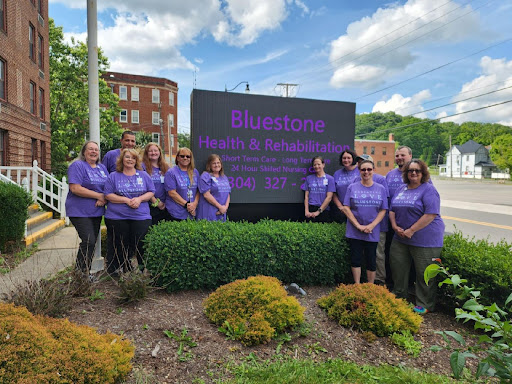 A vibrant group gathered in purple shirts, proudly supporting their cause near the community sign.