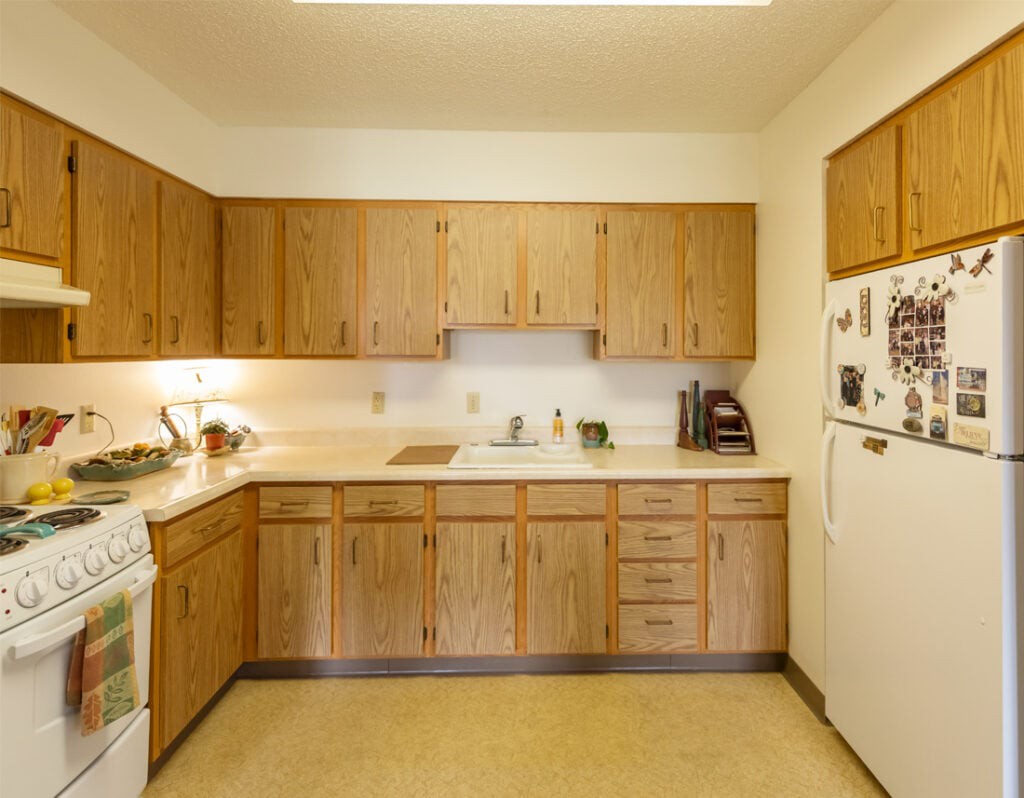 A kitchen with wooden cabinets and standard appliances.