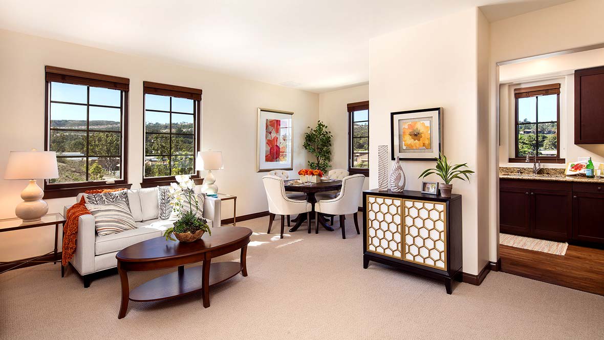 A modern living room with stylish furniture, decorated with plants and art, illuminated by natural light.