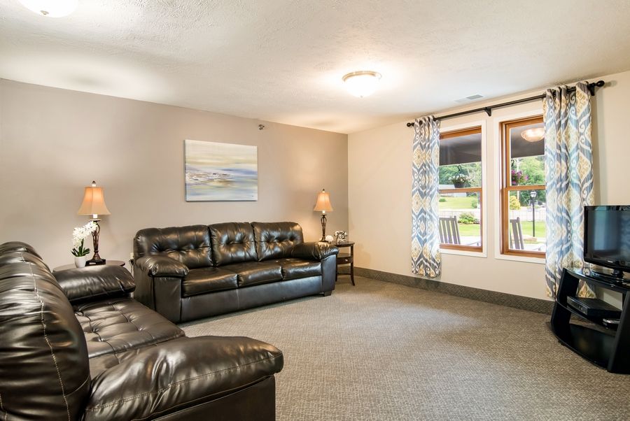 A cozy living room with leather sofas and large windows.