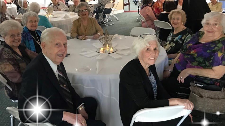 A group of people sitting at a table during an event.