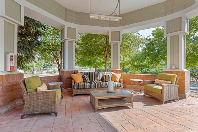 A cozy outdoor seating area with comfortable lounge furniture and a view of the surrounding garden.