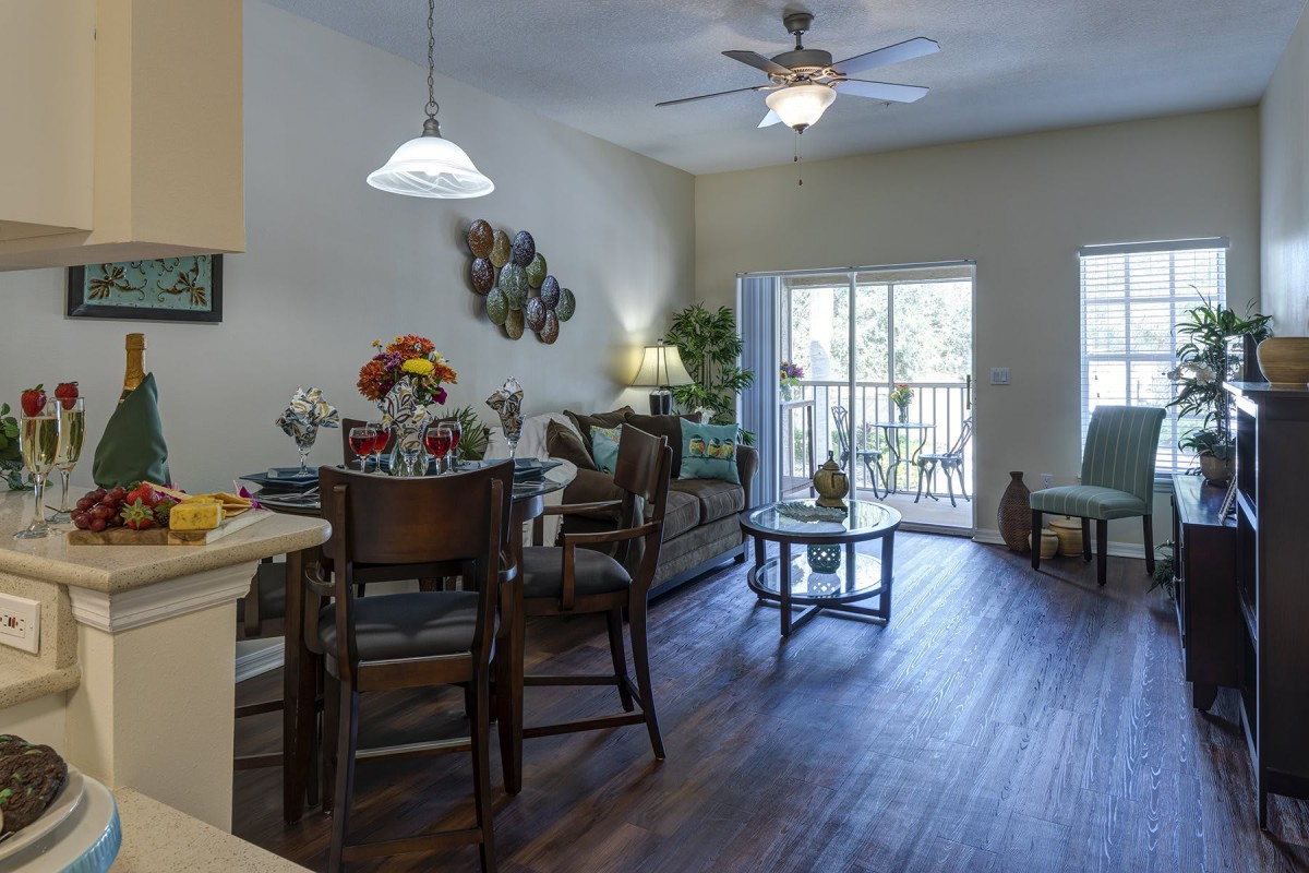 A modern and cozy living room with a dining area, featuring natural light and stylish furniture.