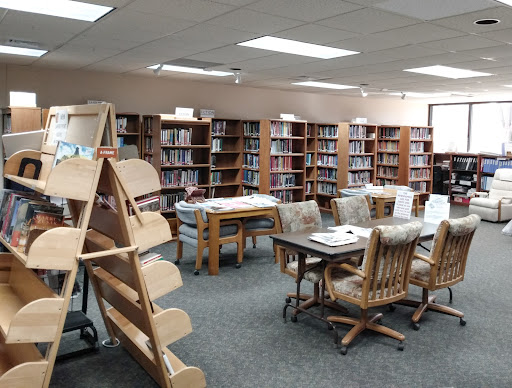 A cozy library featuring rows of bookshelves and a comfortable reading area.