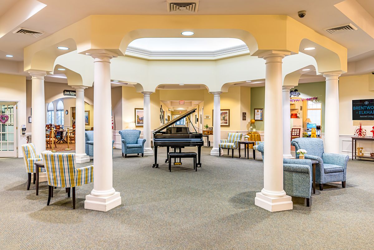 A beautifully designed lobby featuring a grand piano, elegant columns, and comfortable seating areas.
