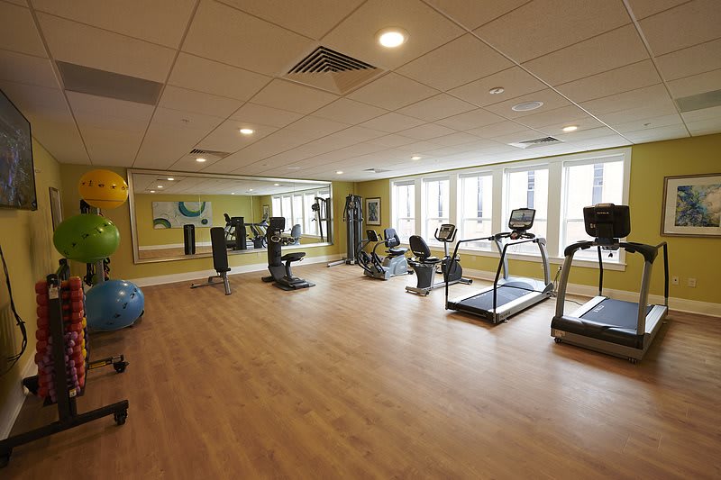 A spacious gym with exercise equipment including treadmills and stationary bikes.