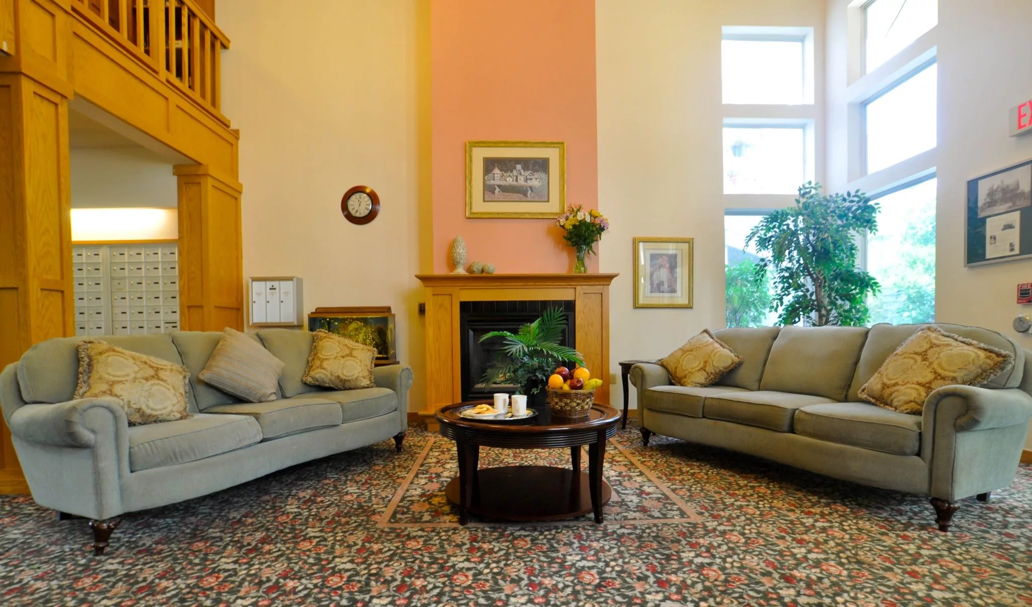A cozy living room with two sofas, a central coffee table, and a fireplace adorned with decorative art pieces.