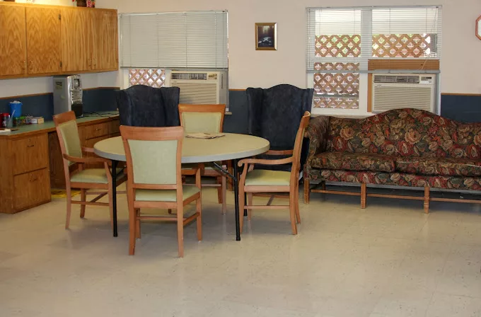 A cozy dining area with a table, chairs, and a couch.