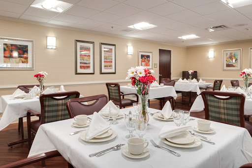 An elegantly arranged dining area featuring a formal table setting with flowers and tasteful decor.