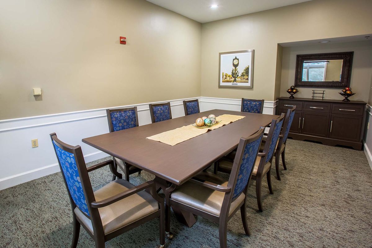 A conference room with a large meeting table and chairs arranged around it.