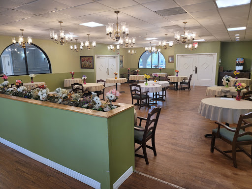 A well-lit dining area featuring elegant chandeliers and neatly arranged tables.