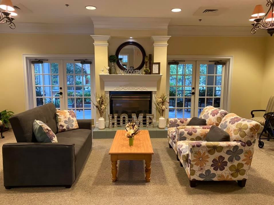 A cozy living room features a fireplace, sofa, armchair, and coffee table with elegant home decor.