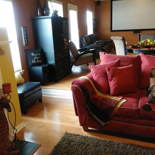 A cozy living room with a red couch and home theater setup.