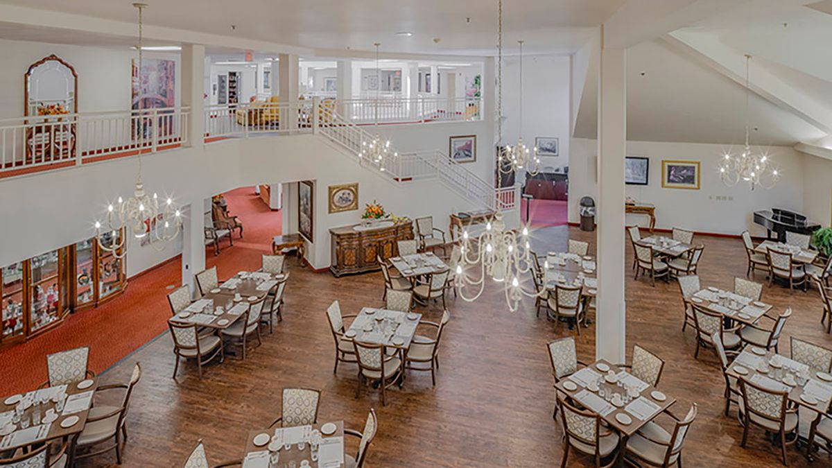 Spacious dining area with elegant chandeliers and neatly arranged tables.