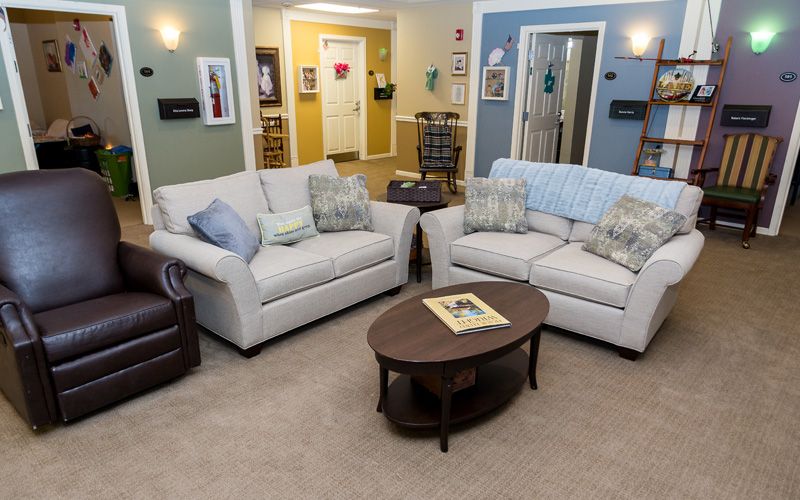 A cozy living room with two sofas and a wooden coffee table in the center.