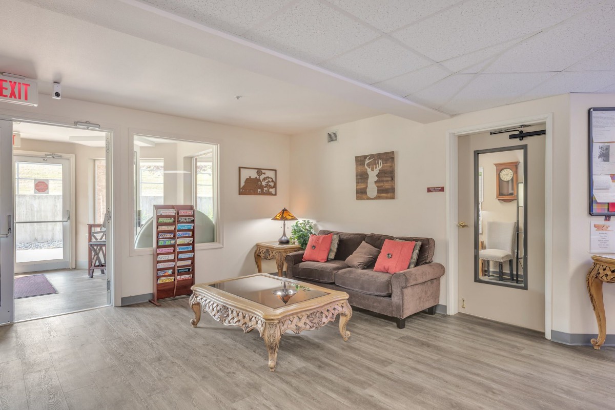 A cozy living room with a comfortable sofa and an ornate coffee table, decorated with stylish artwork and a warm lamp.