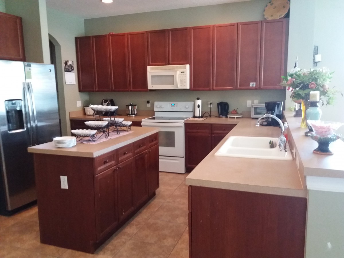 A modern kitchen with wooden cabinets and various appliances.
