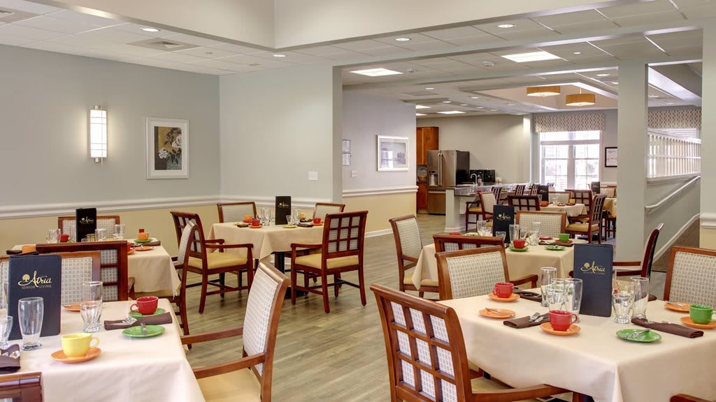 An empty dining room with neatly arranged tables and chairs, ready for service.