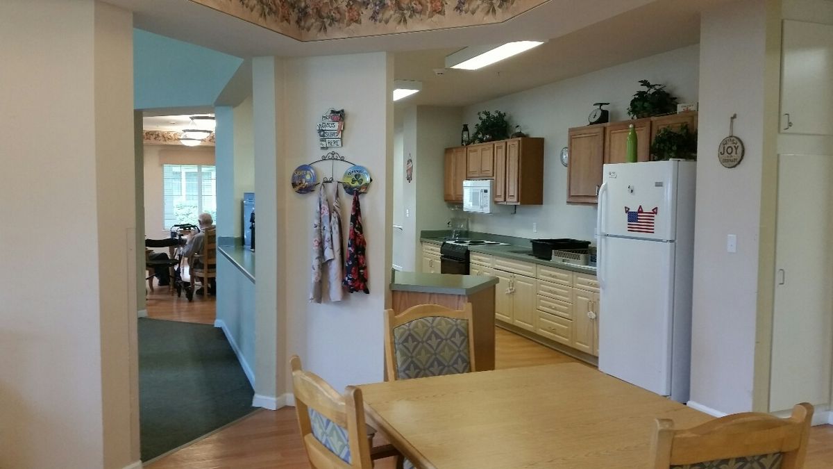 A cozy kitchen and dining area featuring wooden cabinets and a refrigerator.