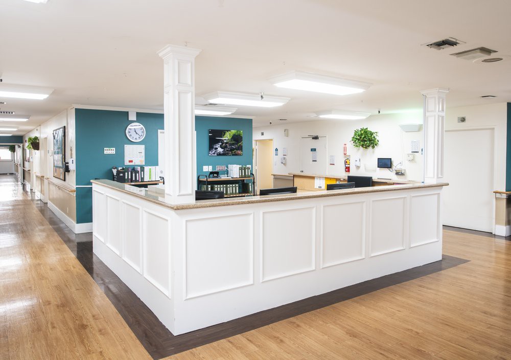 A modern reception area with a central desk and bright lighting.