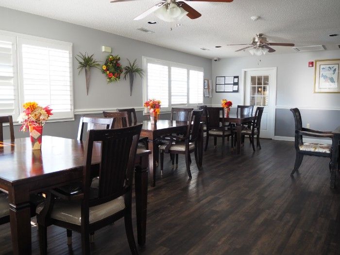 A modern dining room with neatly arranged tables and chairs, decorated with flowers.