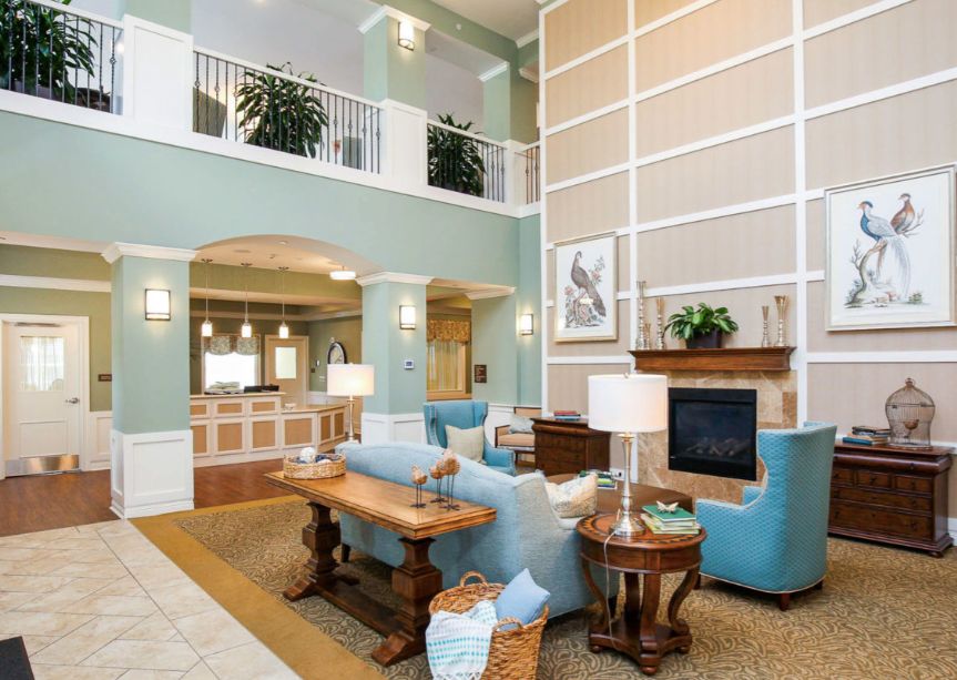 A spacious and elegantly designed living room featuring modern furniture and a cozy fireplace.