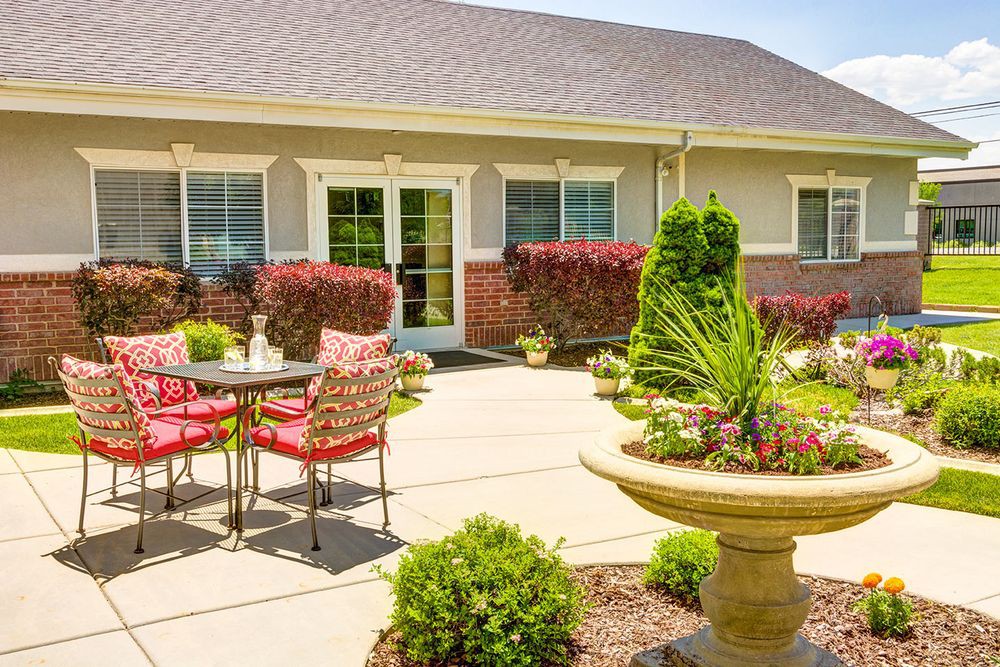 A sunny outdoor patio with a well-maintained garden and comfortable seating.