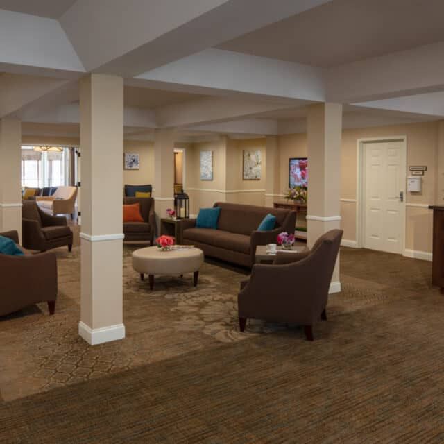 A spacious living room with multiple seating areas and modern decor.