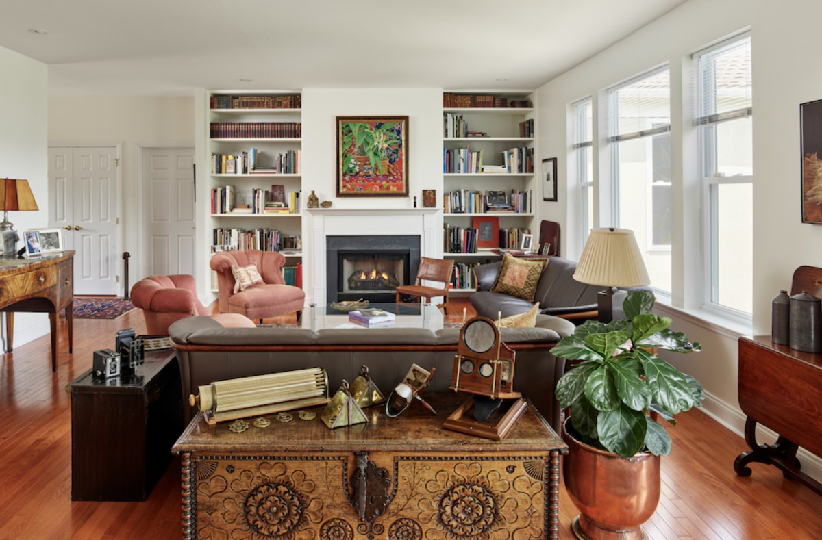 A cozy living room featuring bookshelves, a fireplace, and comfortable seating.