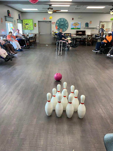 Residents engaging in a fun game of bowling at a community center.
