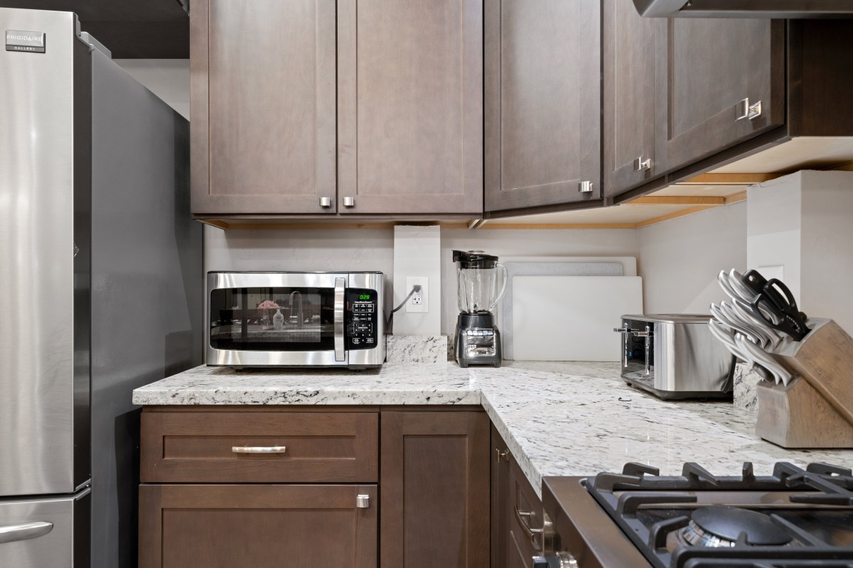 A modern kitchen with countertop appliances including a microwave, toaster, and blender.