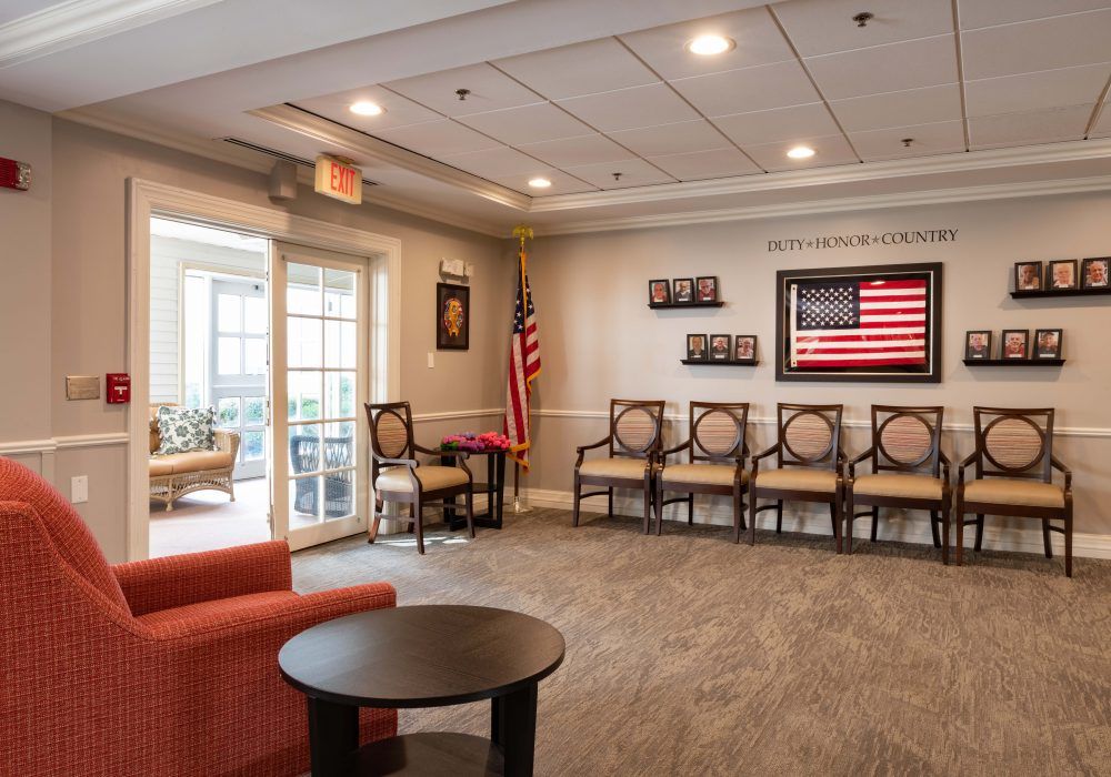 A welcoming waiting room with several chairs, a patriotic theme featuring an American flag and framed pictures.
