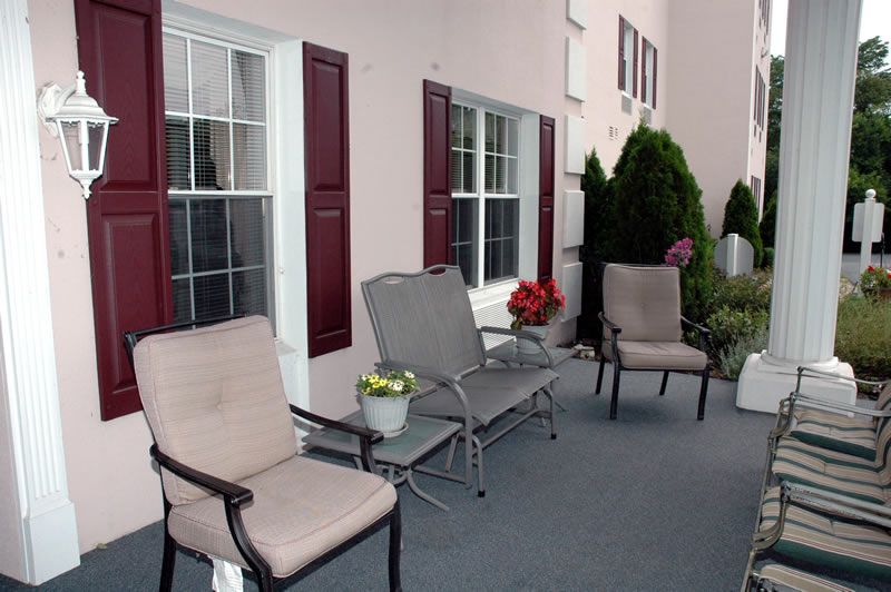 A cozy outdoor patio area with chairs and decorative plants.