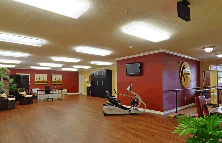 A modern gym interior featuring exercise equipment and vibrant red walls.
