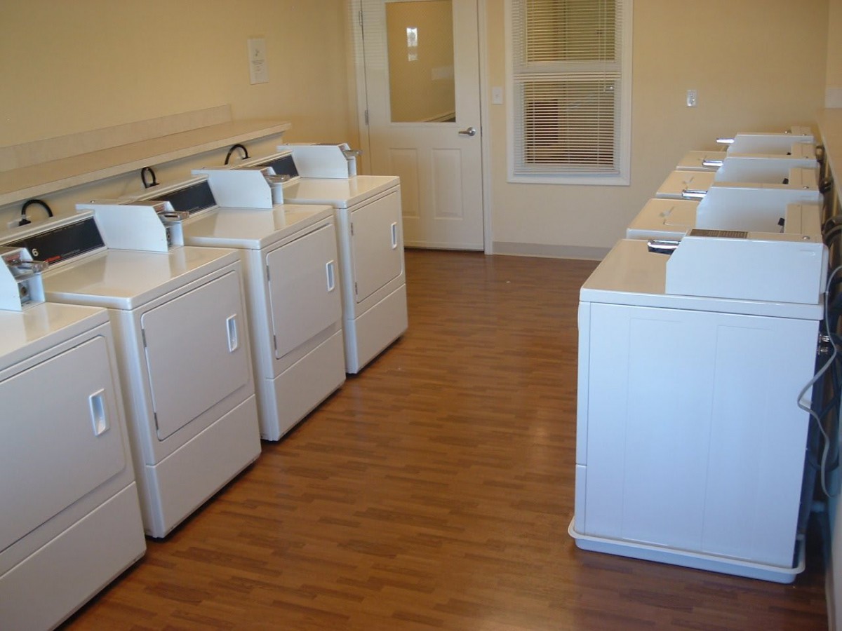 A clean and organized laundry room with multiple washing machines and dryers.