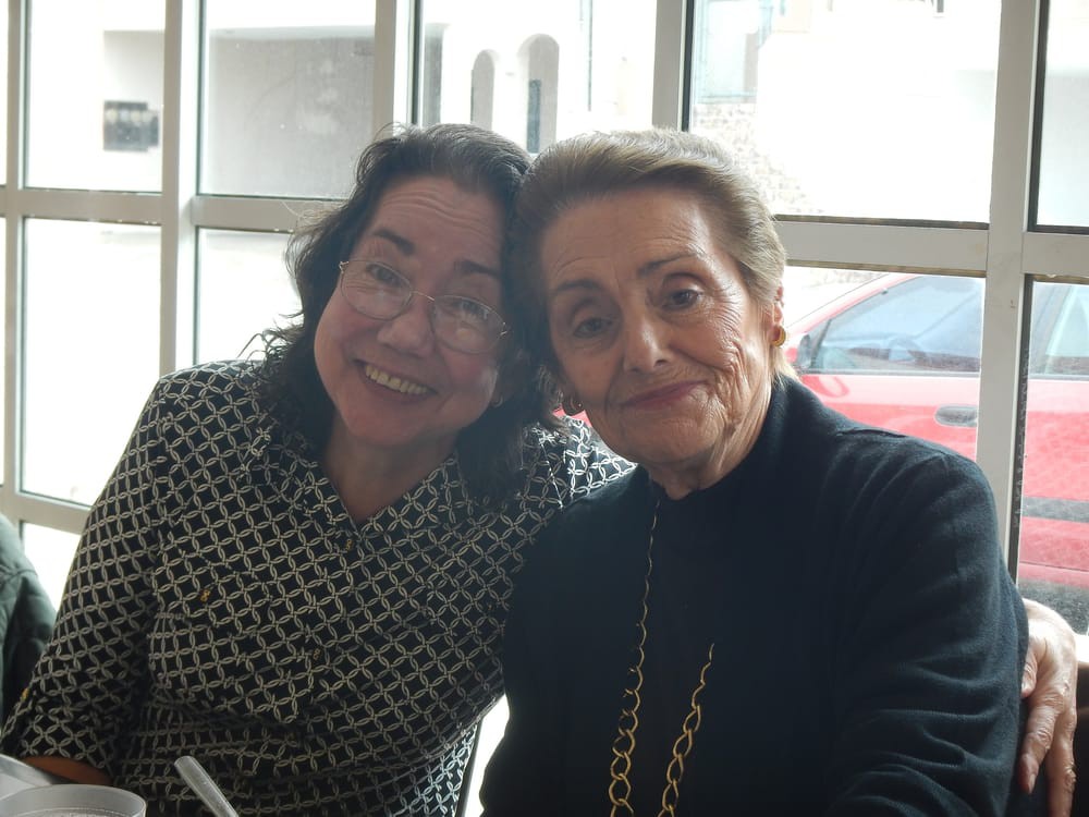 Two women smiling indoors.