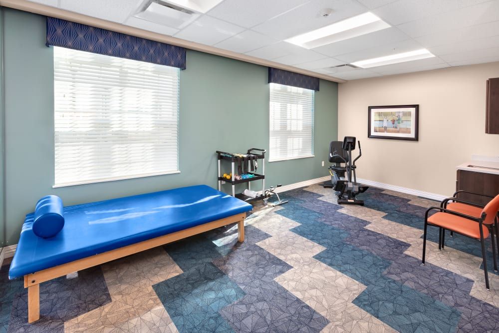 A rehabilitation room equipped with a treatment table and exercise equipment.