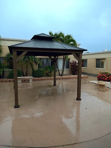 A gazebo in a courtyard, with wet pavement after rain.