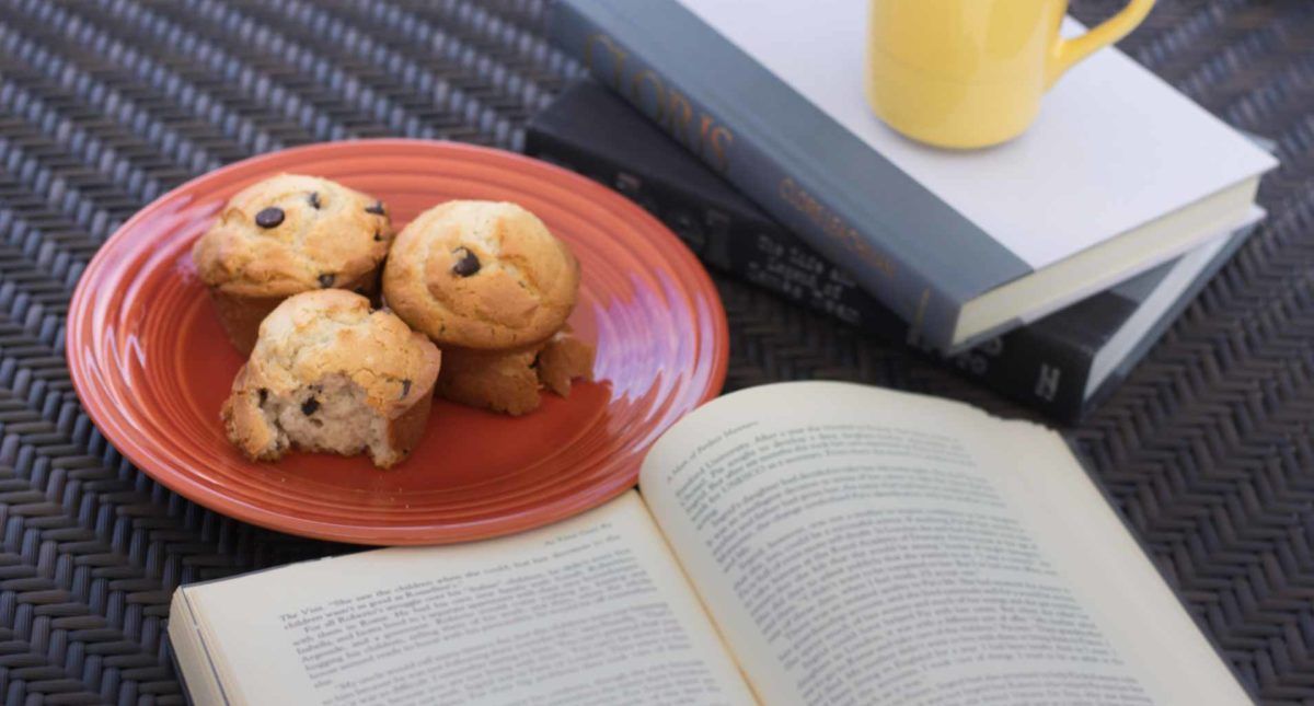 A cozy setup with muffins and books, perfect for a relaxing reading session.