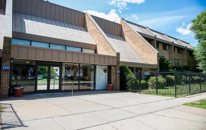 A commercial building with a modern architectural design and an entrance shaded by overhangs.