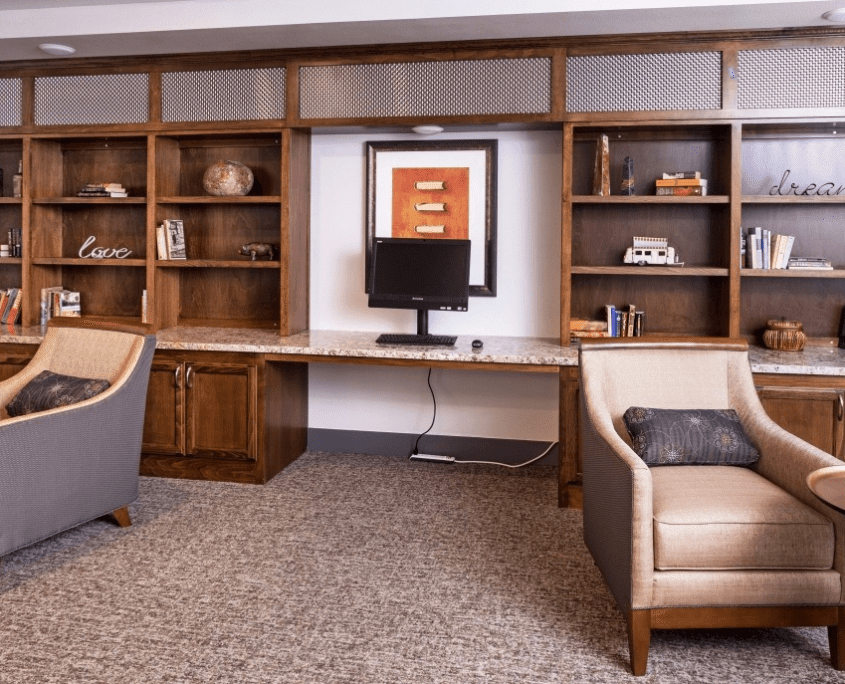 A well-organized office space with bookshelves, a desk, and comfortable chairs.