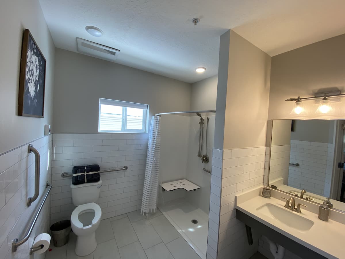 A modern, accessible bathroom with a walk-in shower and safety grab bars.