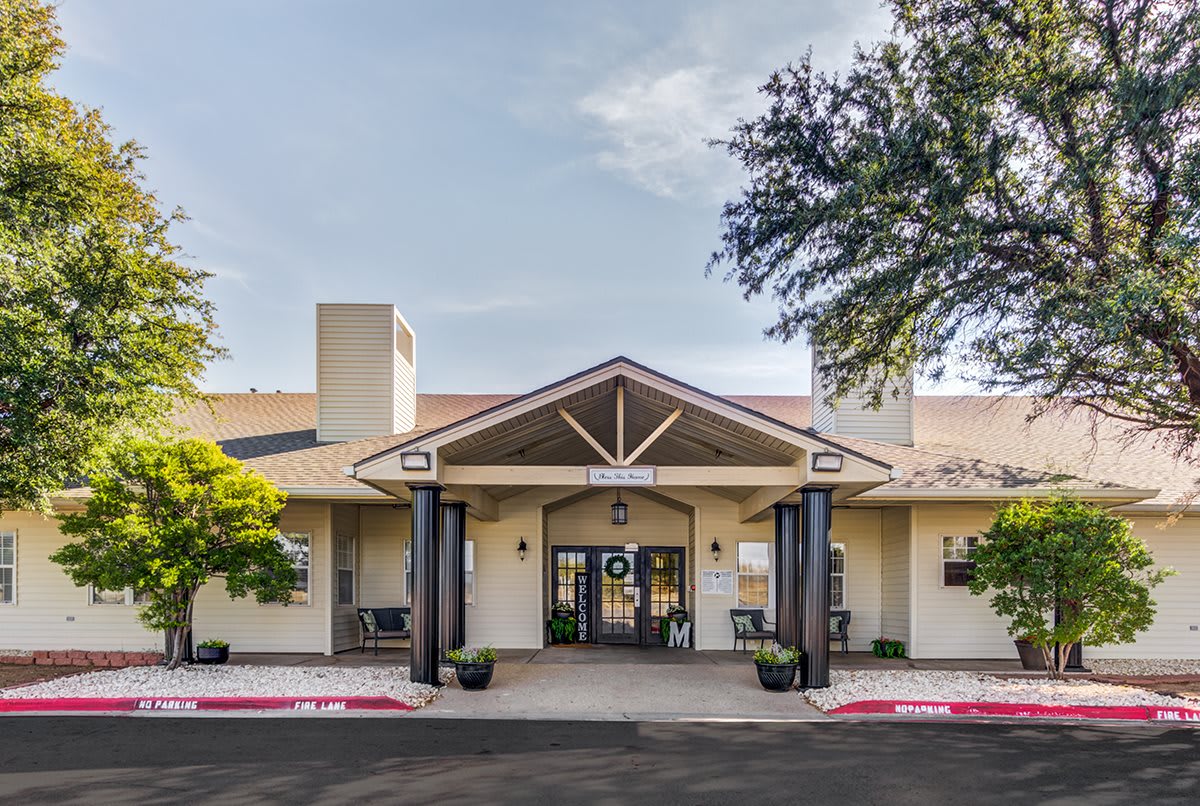 A front view of a building with a welcoming entrance and surrounding trees.