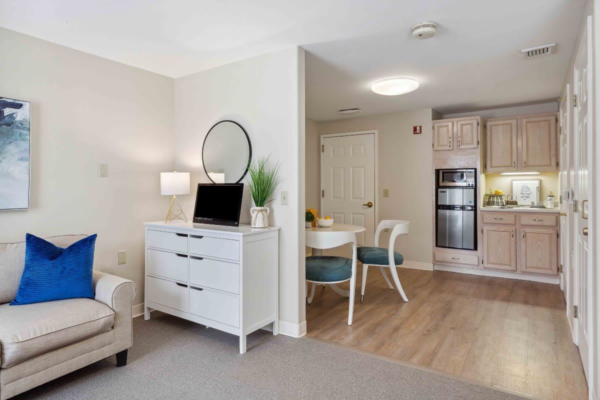 A modern and clean living space with a seamless transition from the living room to the kitchen and dining area.