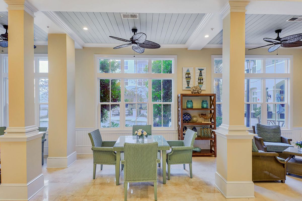 A bright and airy dining area with wicker furniture and large windows.